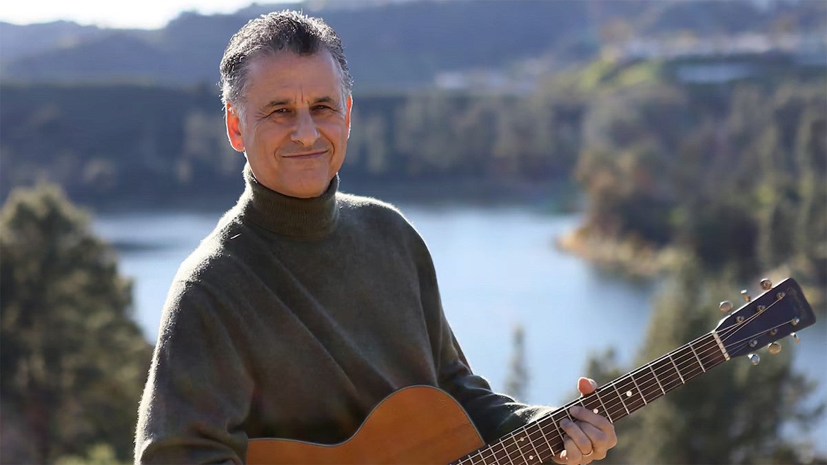 Daniel Levitin hold a guitar outdoors