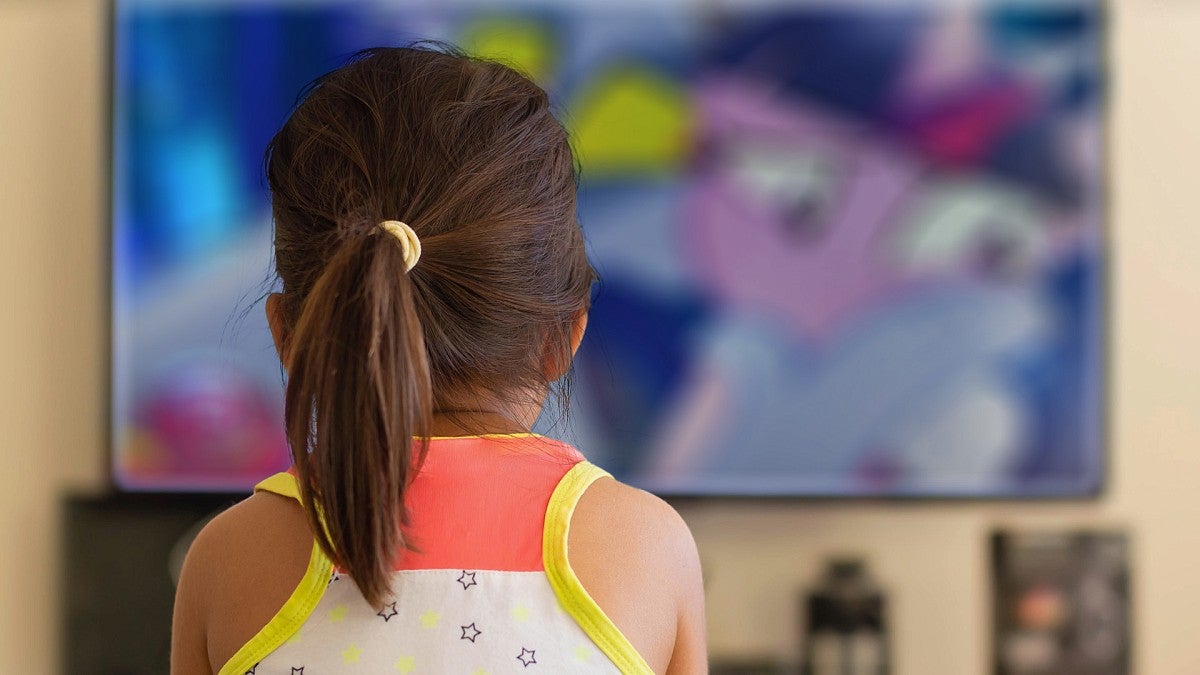 Young girl watching television cartoons