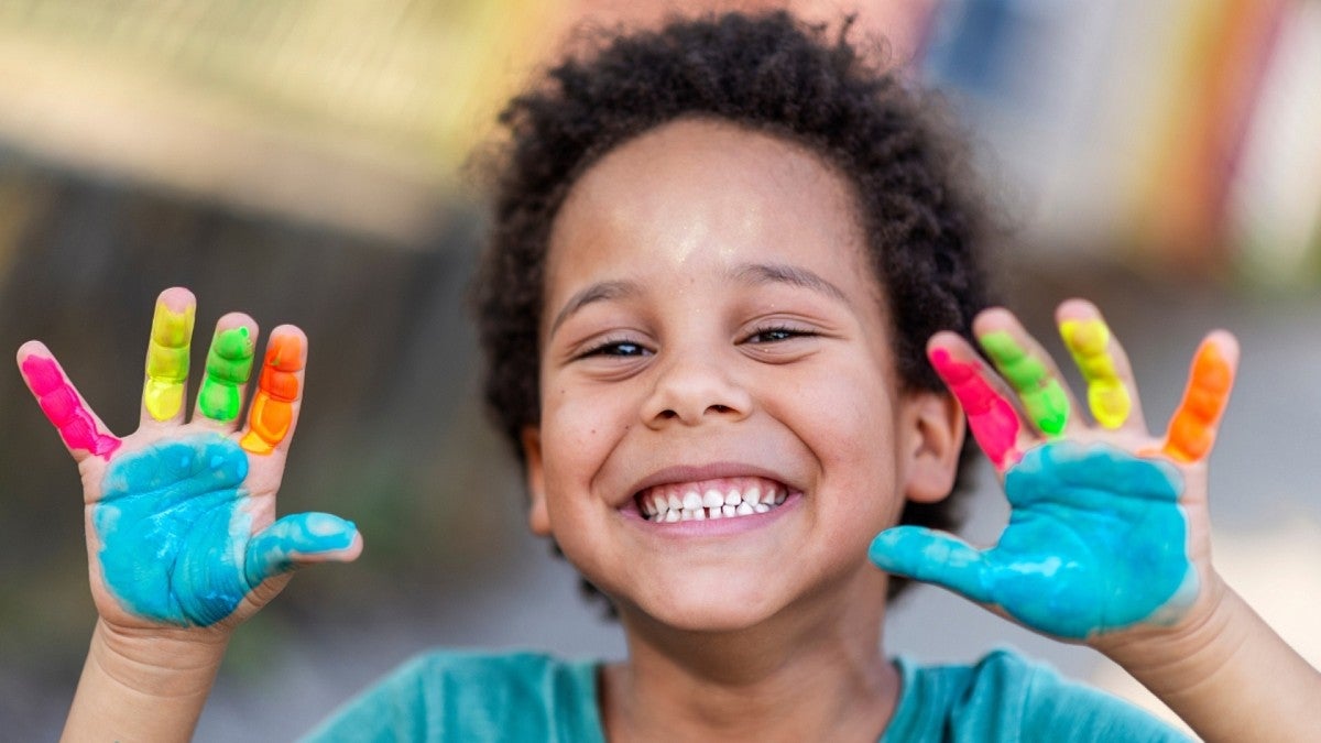 preschool student with painted hands