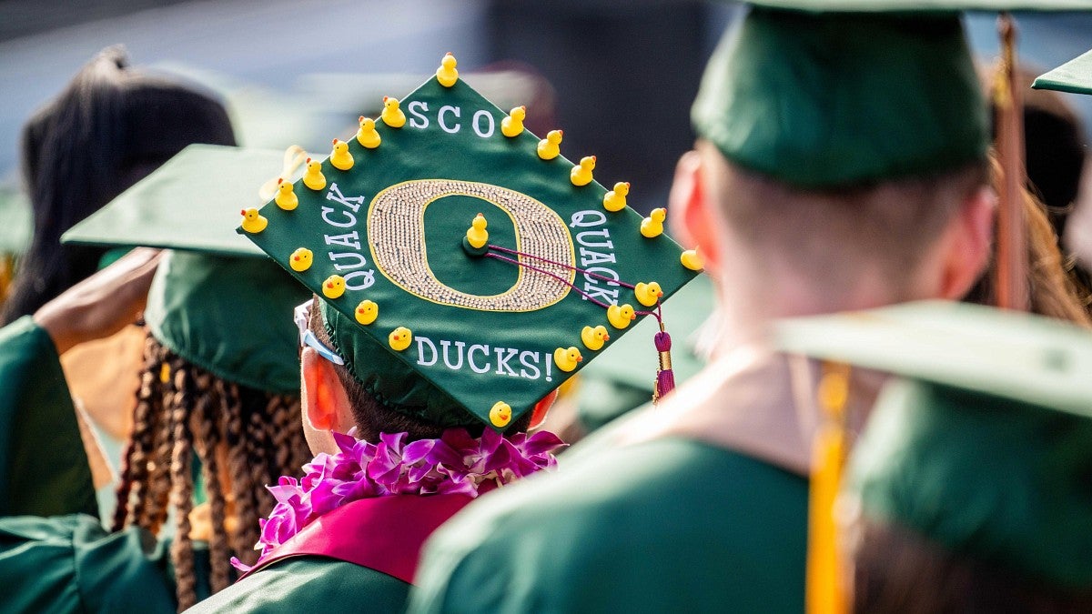 Students in mortarboards, including one with small decorative ducks on the top