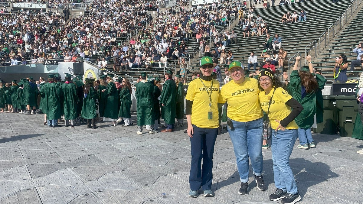 UO employees in yellow volunteer shirts assist at the procession at the university's commencement ceremony