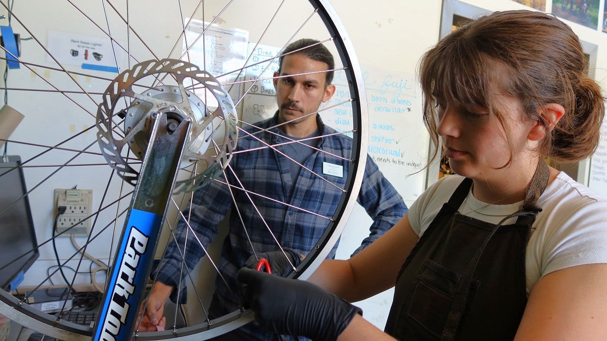 Recent graduate Scout Gesuale (right) learned something new about bike repair every day working as a mechanic with Logan Devack (left), bike program manager (photo: Matt Cooper)