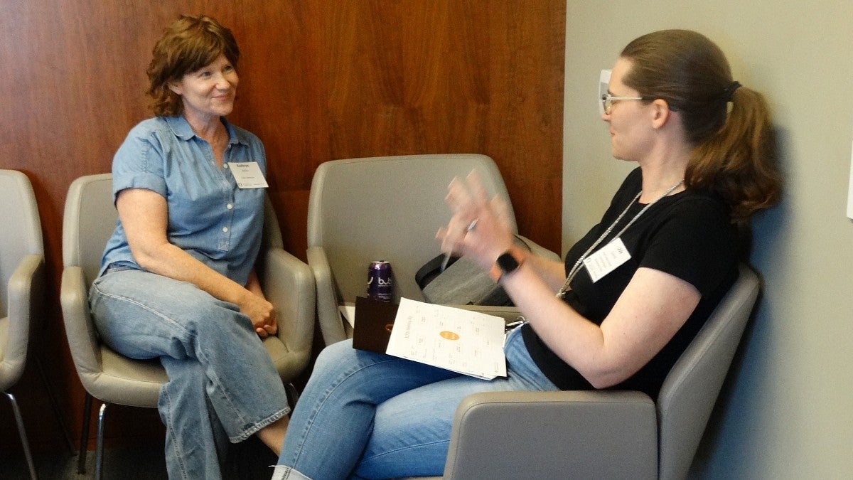 two women sitting across from each other having a conversation