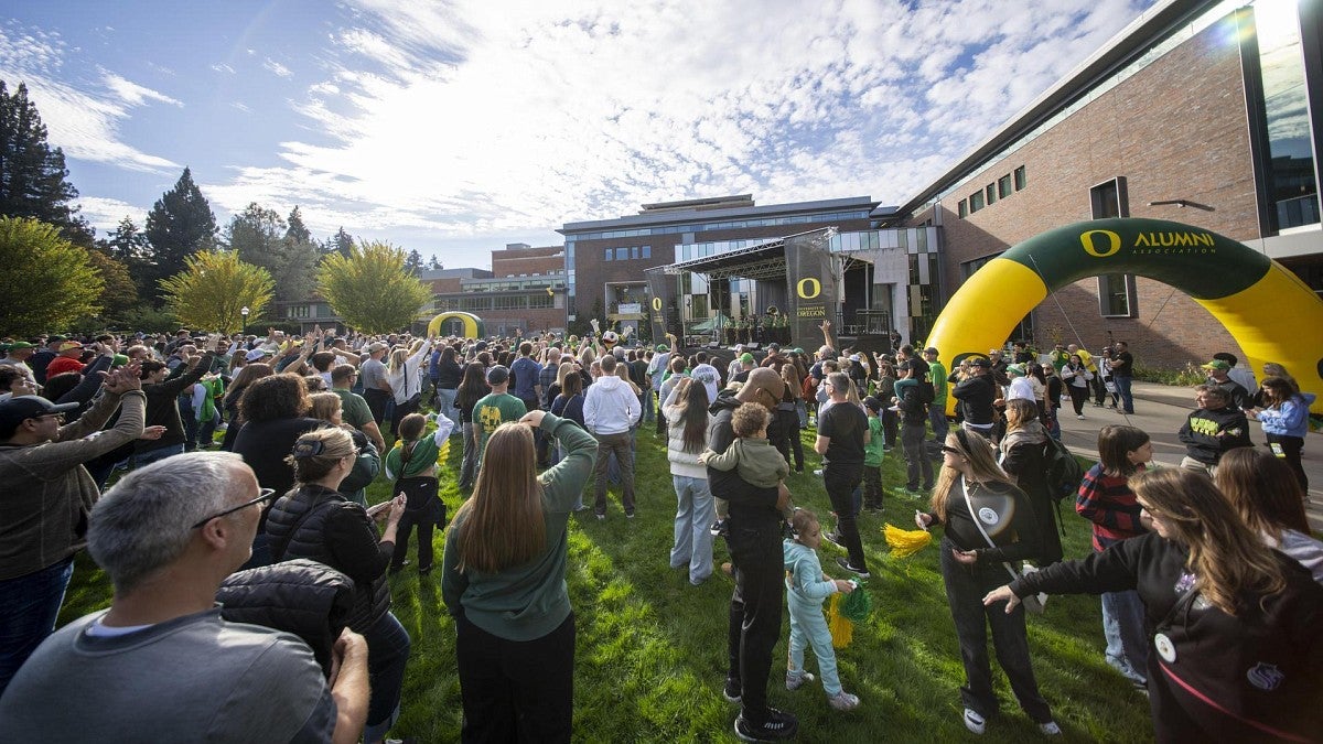 A crowd gathers on grass under a blue sky at a pep rally at the EMU in 2024 (Chris Larsen, University Communications)