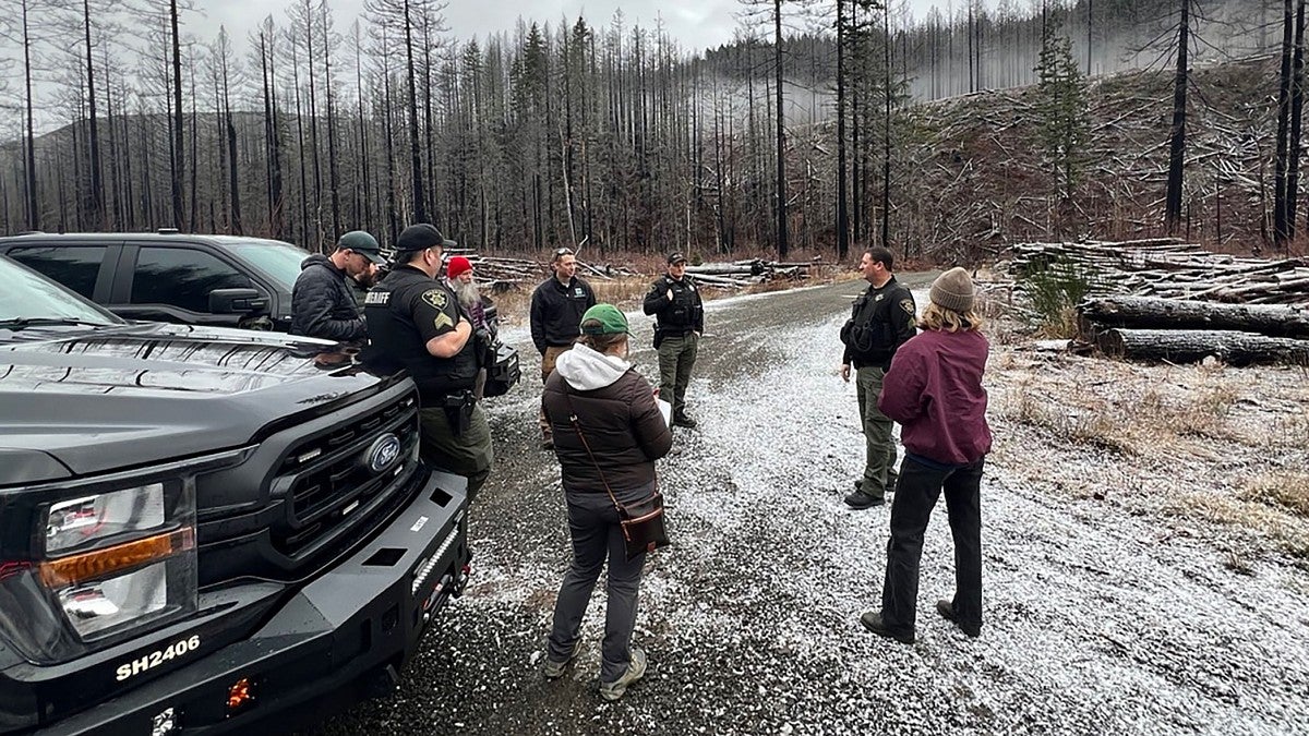 Students talking with law enforcement officers on a remote logging road