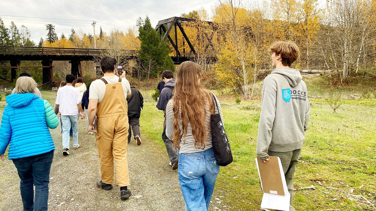 Group of students walking toward a train trestle