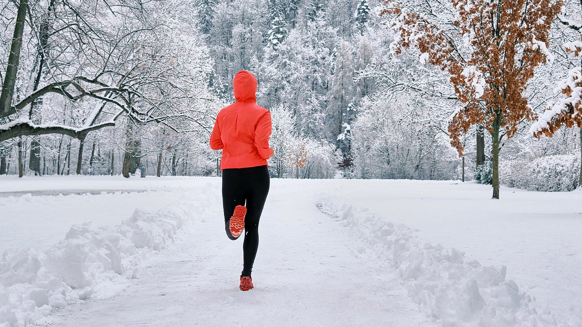 Woman running on snowy road