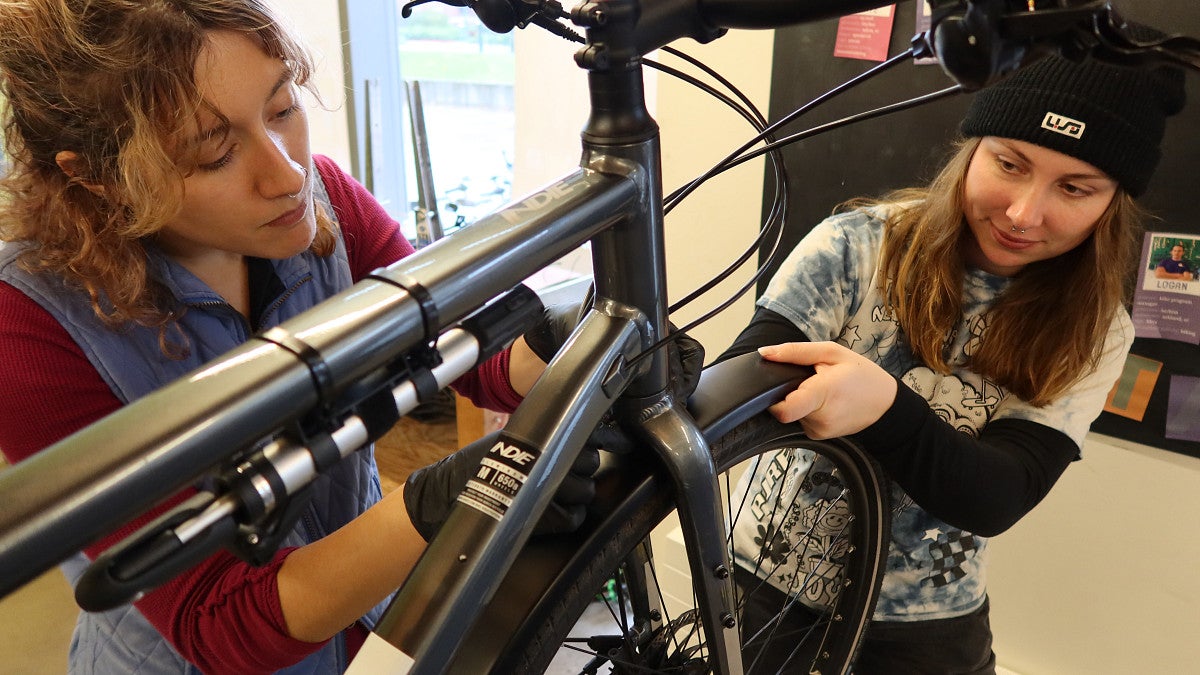 UO Bike Program staffers Kalliope Kyriazis (left) and Phoenix Lester “winterize” a bike by adding full fenders (photo: Matt Cooper, University Communications)