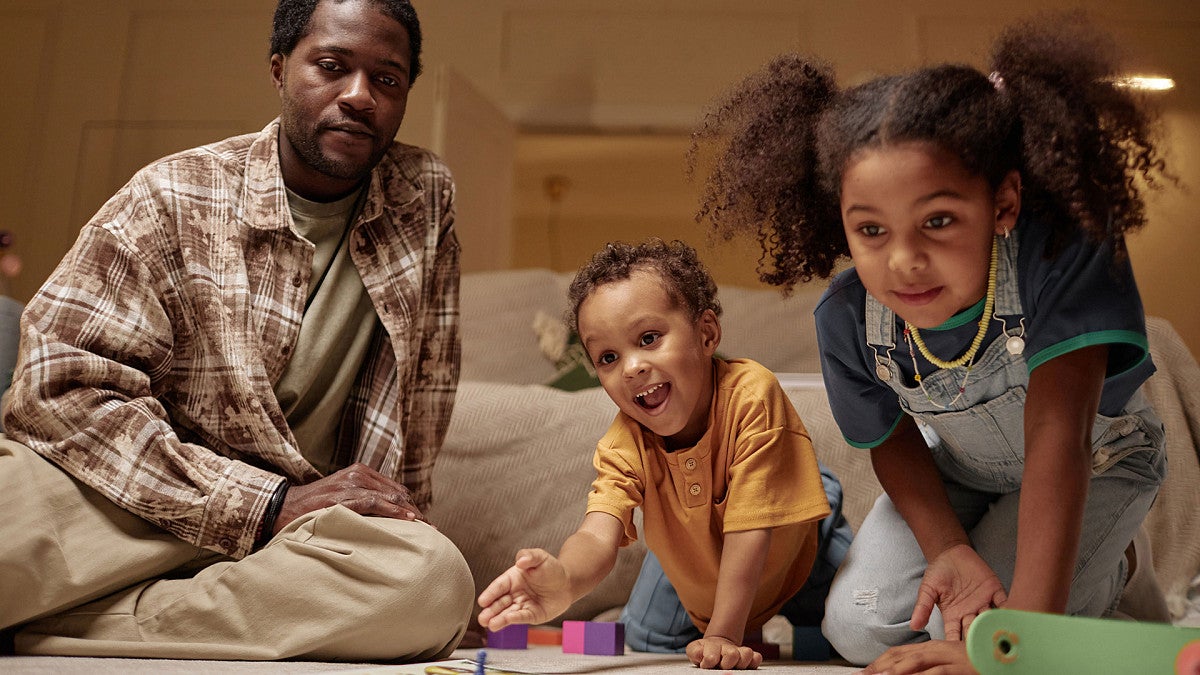 Children playing a board game with a parent