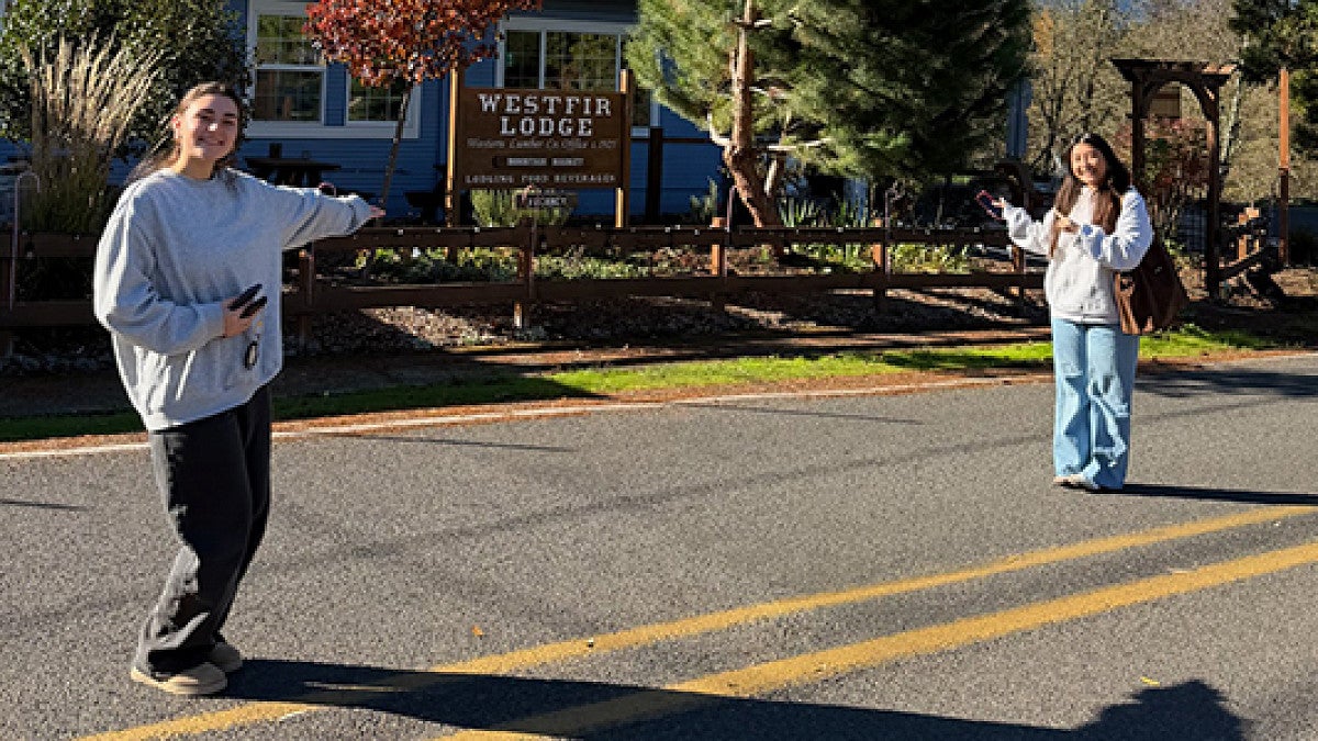 Two women stand outside historic lodge.