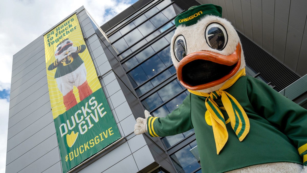 The Duck in front of Ford Alumni Center Ducks Give banner