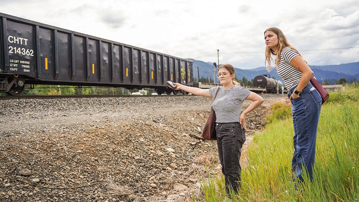 Two students recording sound of train passing by