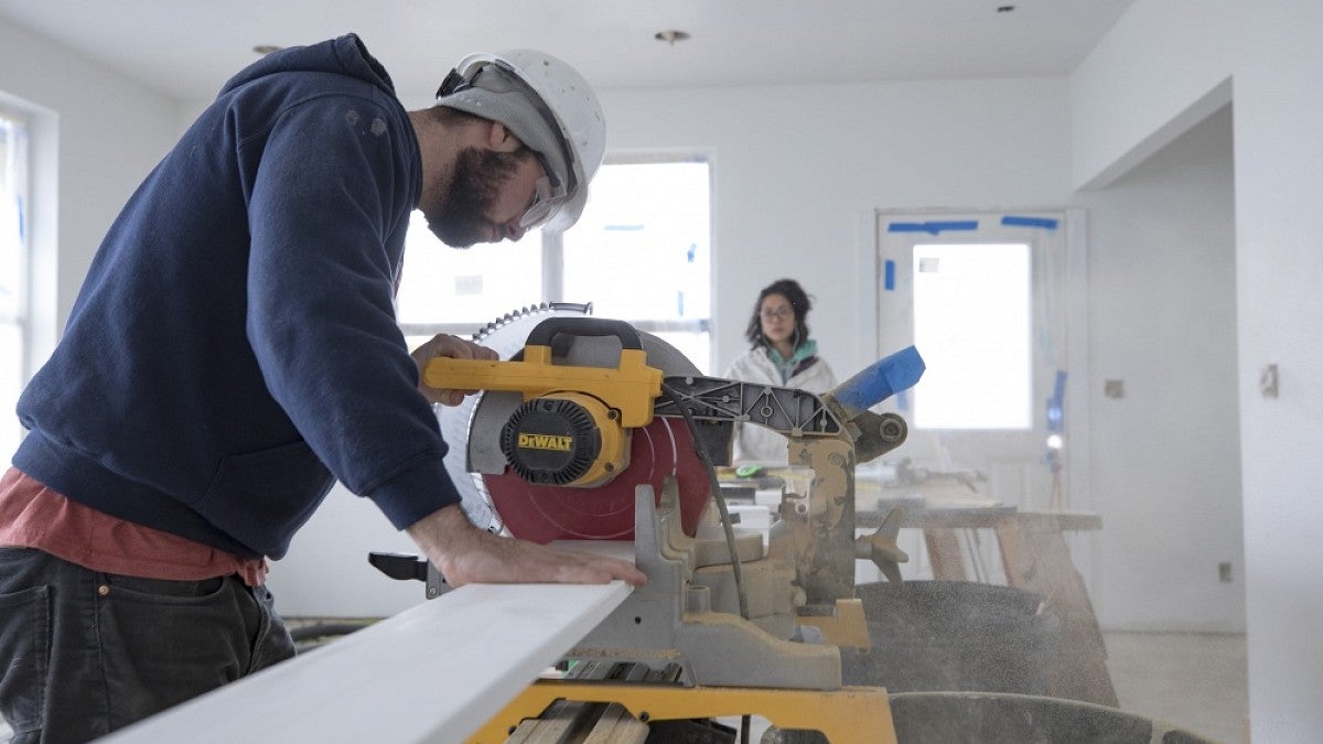 Student sawing baseboard