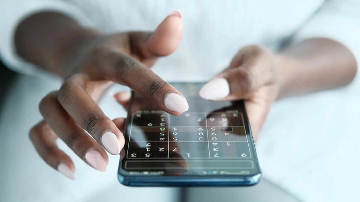 Woman playing soduku on phone