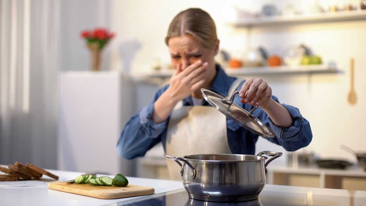 Woman reacts to smell of spoiled food