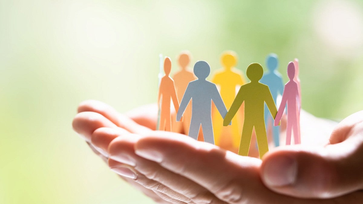 Hands holding paper-doll people