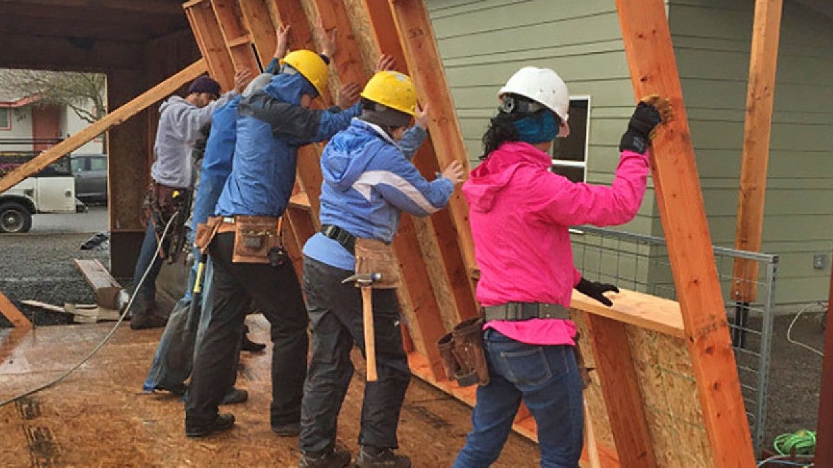 Students in the OregonBILDS studio frame and lift exterior walls into place.