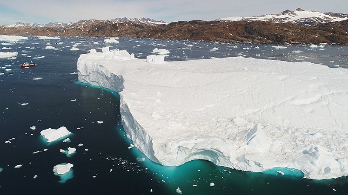 Large iceberg in Sermilik Fjord makes a research vessel appear to be tiny 