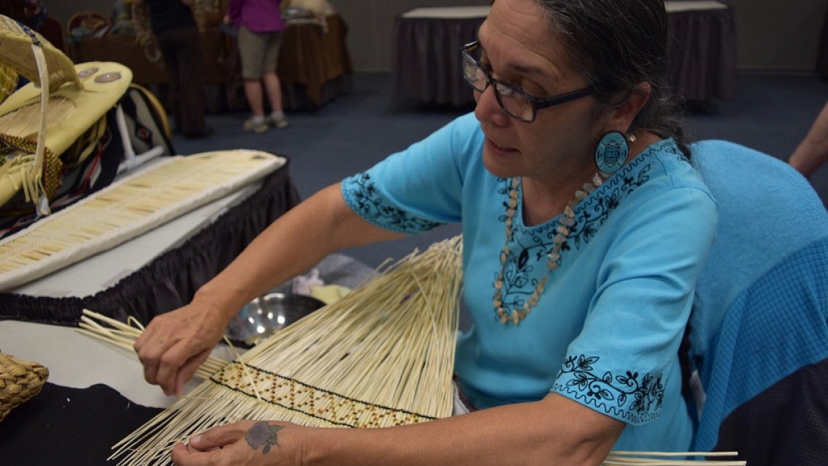 Sara Barton works on a cradleboard 