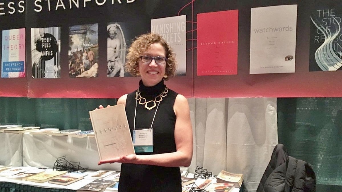 Professor Balbuena holds a copy of her new book