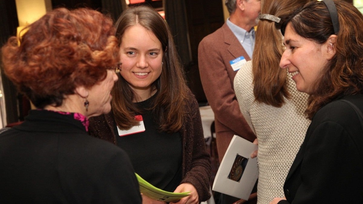 People talking at a previous reception for new women faculty.