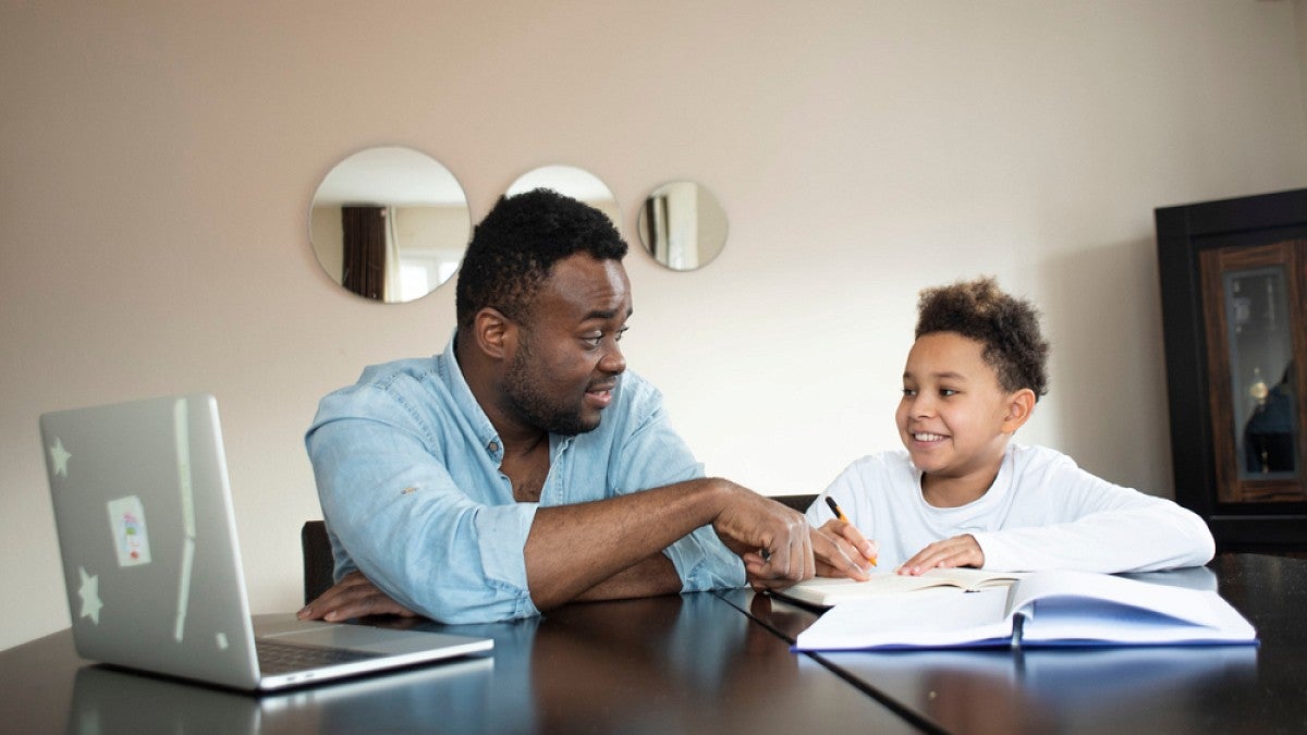 Stock image of man and child working on school