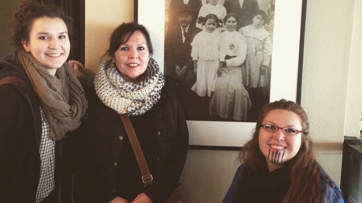 Kelly LaChance and her daughters in front of a family picture