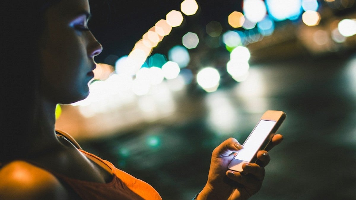 Woman with cellphone at night