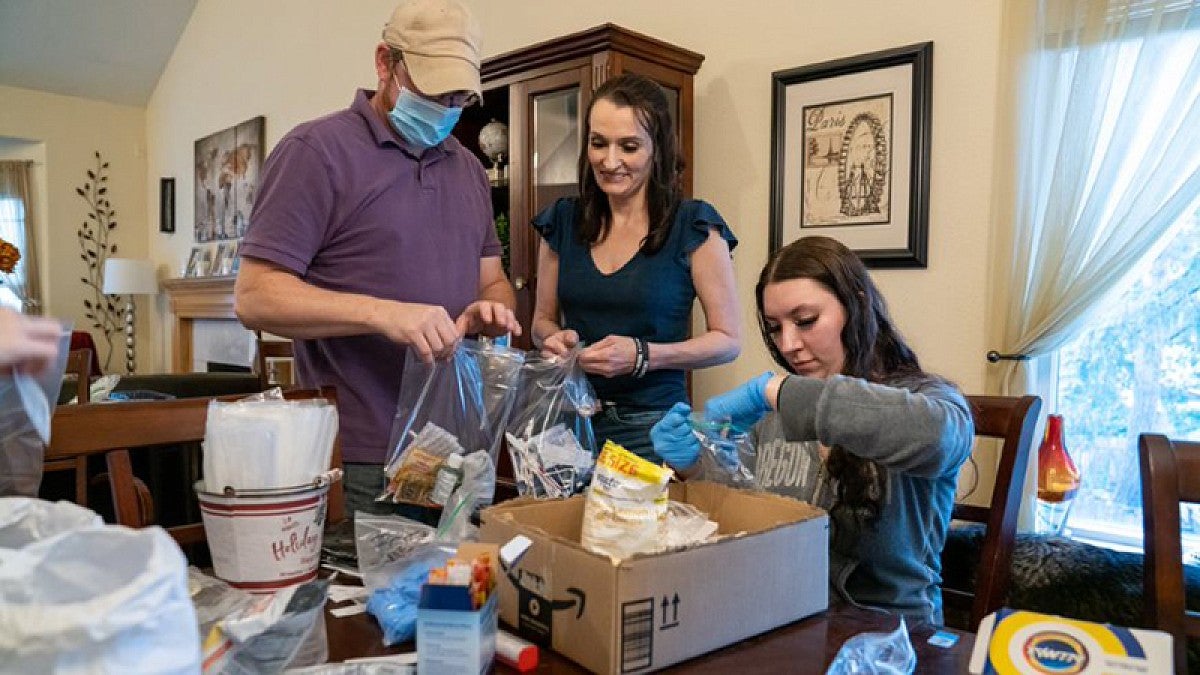 Shawna Heurgue with family making kits for the homeless