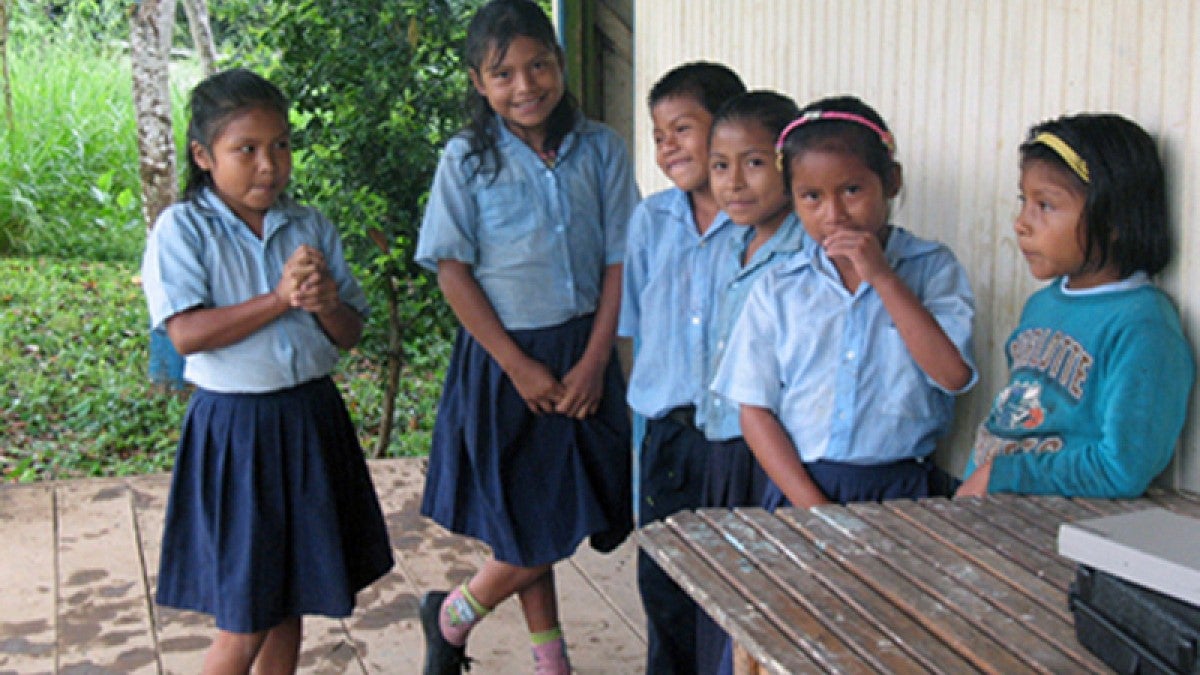 Shuar children in uniform outside a building 