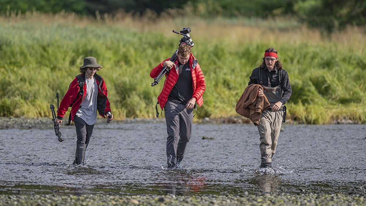Students wading a river in Alaska