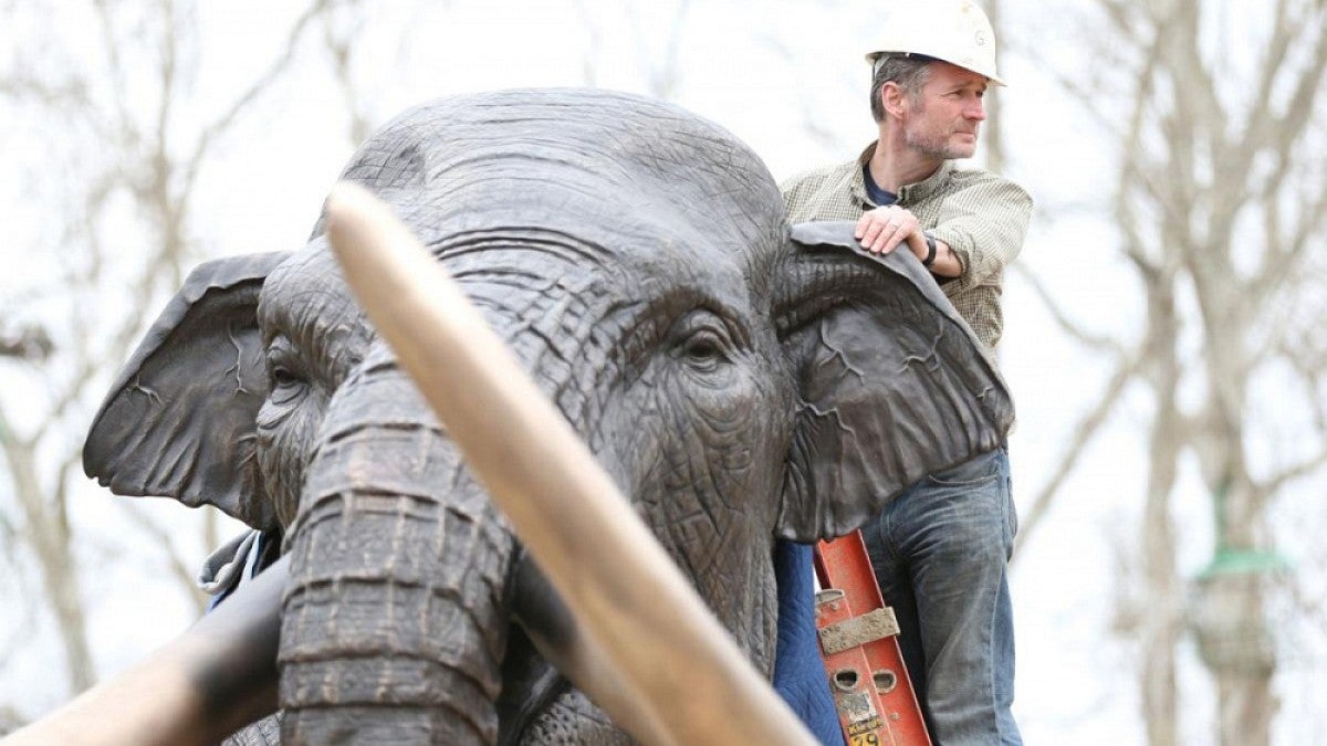 Artist on mammoth sculpture