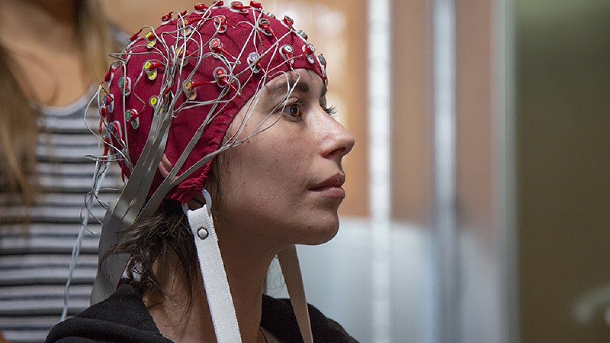 Image shows a subject wearing cap covered in electrodes
