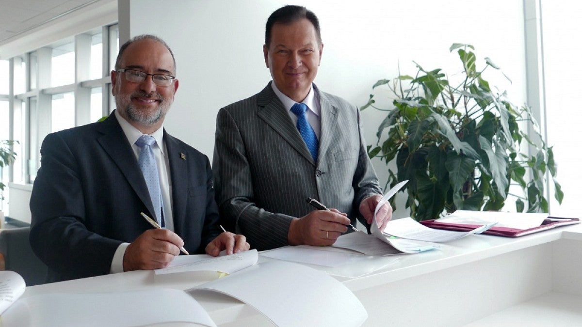 Dennis Galvan (left) signing agreement with his Russian counterpart.