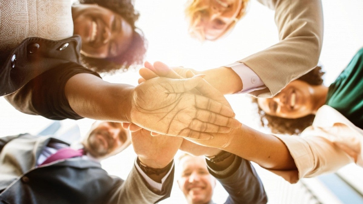 People with hands extended in a circle