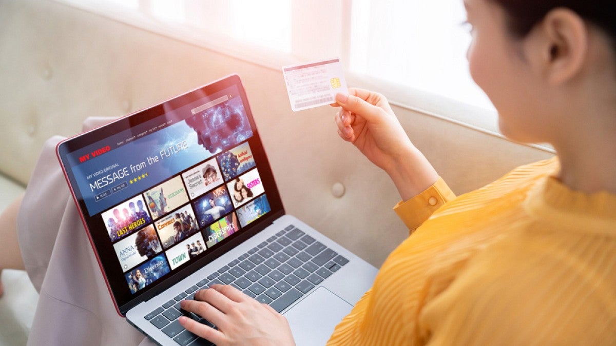 Woman selecting video on laptop
