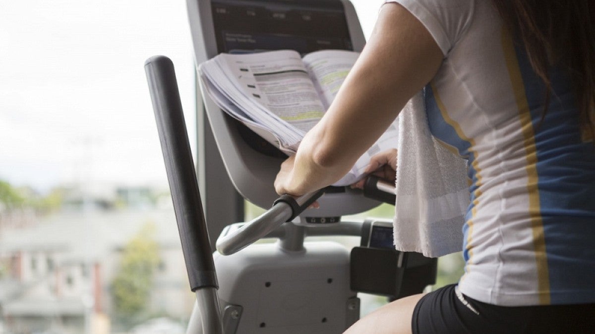 Woman studying on exercise machine