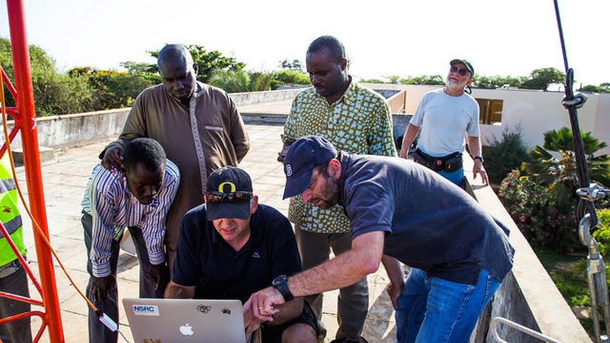 Phil Regnauld (NSRC), Ermanno Pietrosemoli and Marco Zennaro of ICTP Italy working with network engineers to install a high-speed, point-to-point wireless link at the Université Cheikh Anta Diop in Dakar, Senegal.