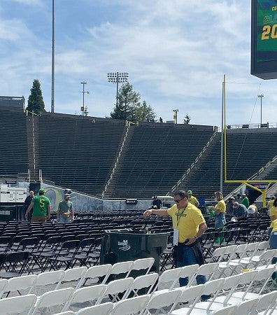 Volunteer collecting trash after a commencement ceremony