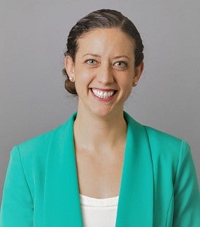 Elizabeth Day smiling wearing a turquoise jacket and a white shirt