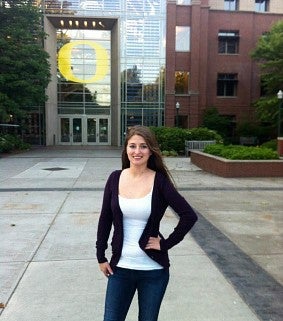 Julia posing for a photo in front of the Lillis Business Complex