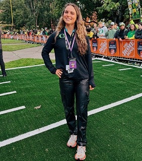 A student poses near fencing that reads The Home Depot close to the set of College GameDay