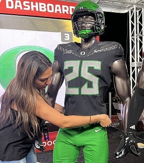 A student dresses a mannequin in Ducks football gear on the set of College GameDay