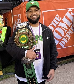 A man in a Ducks cap poses in front of Home Depot branding at College GameDay