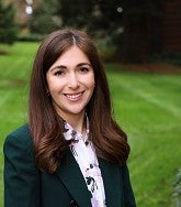 A professional portrait of Jessica Gamlin outdoors with trees and grass in the background.