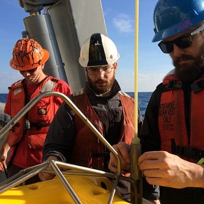 Photo of two UO grad students prepping a seismometer for deployment