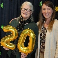 Jen Strong (left) and Shelley Elliott hold "20" balloons.