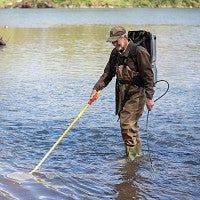 Biologist Jeff Ziller lightly stuns fish so they can be captured and counted